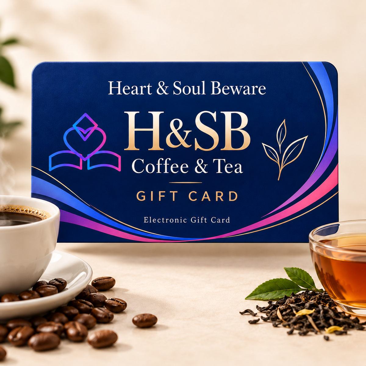 A Heart & Soul Beware Coffee & Tea gift card is displayed on a light beige surface with coffee beans, a cup of black coffee, and a glass of tea. The card features a deep blue background with gold and pink accents and the text 'Heart & Soul Beware H&SB Coffee & Tea Gift Card'.